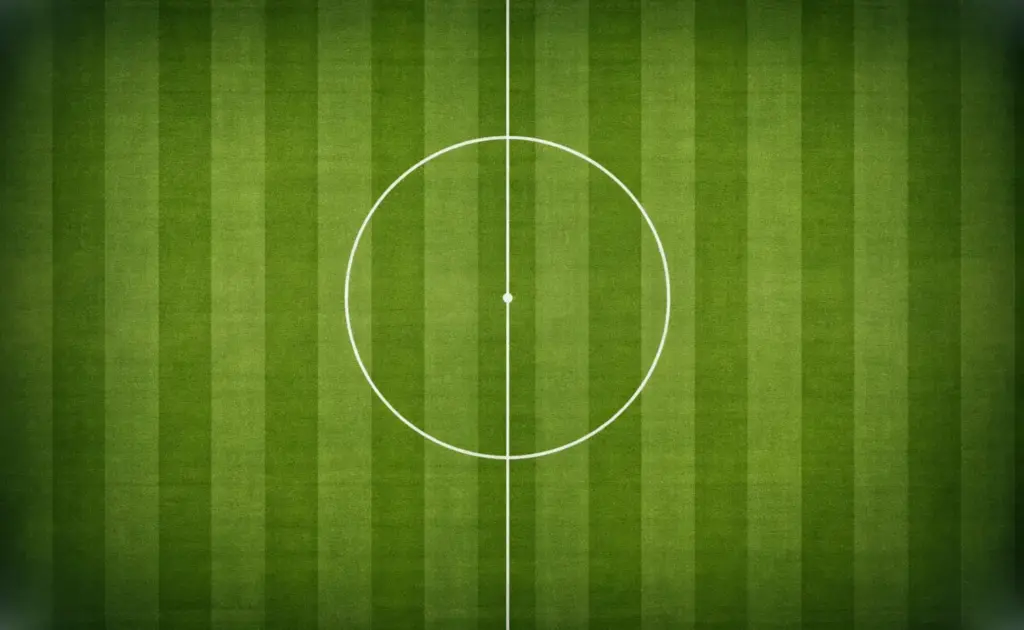 Vue plongeante sur un terrain de football avec les lignes de jeu nettes sous un éclairage de stade puissant